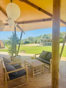 a patio with a couch and chairs and a table at Quinta da Boa Sorte in Estói