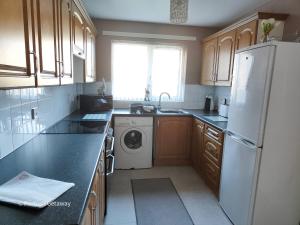 a kitchen with a refrigerator and a washing machine at Portrush Getaway - Holiday Let in Portrush