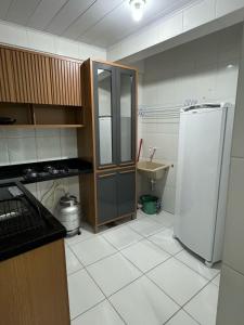 a kitchen with a refrigerator and a tile floor at Ed Odilon Vieira 104 in Vitória da Conquista +6 photos