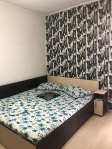 a small bedroom with a bed with a comforter at Casa Elena in Constanţa