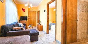 Una sala de estar con un sofá y un televisor. en Maria's Apartment with private parking, en Paralia Katerinis