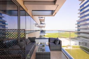 einen Balkon mit einem Sofa und einem Tisch in der Unterkunft Voyage Studio In Mayan With Partial Ocean Views in Abu Dhabi