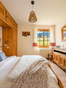 a bedroom with a large white bed and a window at Rare, quite & centered Apartment with Garden & Fireplace in Villars-sur-Ollon