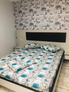 a bedroom with a bed with blue and white sheets at Casa Elena in Constanţa