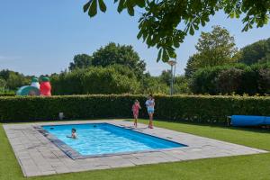two girls are standing in a swimming pool at Siblu De Lente van Drenthe in Gasselte