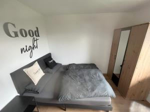 a bedroom with a couch and a sign that reads goodnight at Ferienwohnung AusZeit 1 in Ainring