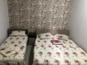 a small bedroom with a bed and a wall with a wallpaper at Casa Elena in Constanţa