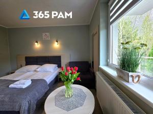 a bedroom with two beds and a vase of flowers on a table at 365PAM - Studio C35 Dominikana in Sianozety