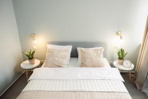 a bedroom with a bed and two tables with plants at Apartament Szczerbowskiego A in Lublin