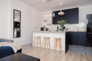 a kitchen and living room with a counter and stools at Apartament Szczerbowskiego A in Lublin