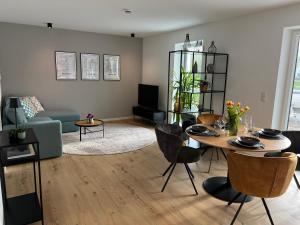 a living room with a table and a couch at Olea Prien - Chiemsee Apartment in Prien am Chiemsee