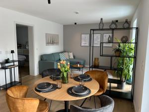 a living room with a table and chairs at Olea Prien - Chiemsee Apartment in Prien am Chiemsee