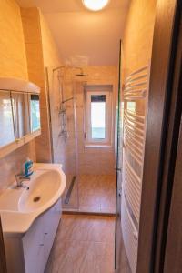 a bathroom with a shower and a sink at Golden Beach Apartments Siófok by BLTN in Siófok +25 photos