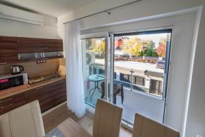a kitchen with a large window with a view of a street at Golden Beach Apartments Siófok by BLTN in Siófok