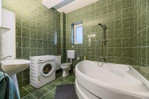 a bathroom with a tub and a washing machine at FLH - Emprin House in Predeal +44 photos