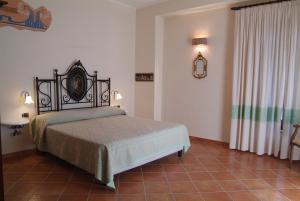 a bedroom with a bed and a tiled floor at Agriturismo La Casa Di Botro in Botricello