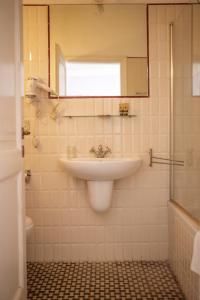 a white bathroom with a sink and a shower at Villa Maddalena - Cerrolungo in Isola
