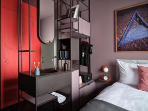 a bedroom with a bed and a sink and a mirror at lyf East Frankfurt in Frankfurt
