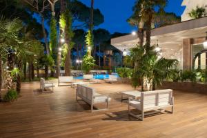 a patio with benches and trees at night at Hotel Belvedere in Milano Marittima