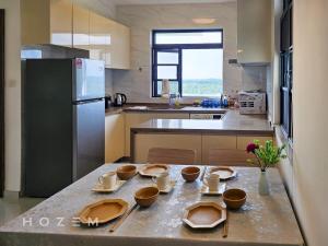 振林山2BR2B Hozem JB0806 Apartment Forest City的厨房配有带盘子和碗的桌子