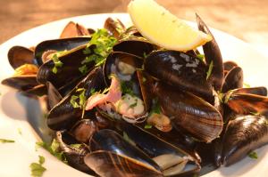 a plate of mussels with a slice of lemon on top at The Dolphin Inn in Thorpeness