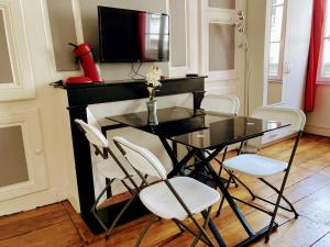 a dining room with a glass table and white chairs at STUDIO double 21 centre de LIMOGES WIFI in Limoges