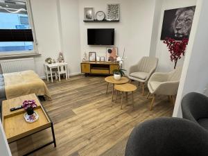a living room with a couch and tables and a tv at Mahesars Home in Gevelsberg