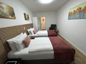 a hotel room with two beds and a chair at Mahesars Home in Gevelsberg