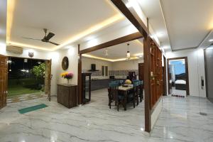 a kitchen and dining room with a table and chairs at VanRaj Farm in Greater Noida