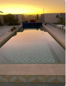 a pool of water with a sunset in the background at Casa Bonita in El Pescadero