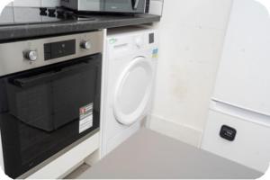 a kitchen with a microwave and a dishwasher at Douglas Home in Hayes