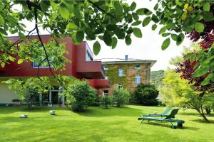 eine Bank, die im Gras vor einem Gebäude sitzt in der Unterkunft Hotel Villa Sanct Peter in Bad Neuenahr-Ahrweiler