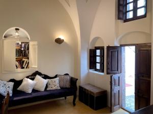a living room with a couch and a book shelf at The Commander's House in Emporio Santorini