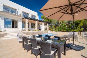 a patio with a table and an umbrella at CostaBlancaDreams Casa con Vista in Calpe in Empedrola