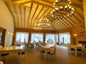 une salle à manger avec tables et chaises et un lustre dans l'établissement Magnolia Family Boutique and Spa, à İvanovka