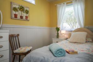 a bedroom with a bed and a chair and a window at South Devon - River Dart Views - Free Parking - Pet Friendly in Galmpton-on-the-Dart