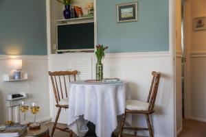 a table with two chairs and a vase on it at South Devon - River Dart Views - Free Parking - Pet Friendly in Galmpton-on-the-Dart