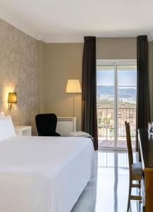 a hotel room with a large bed and a balcony at Sol Guadalmar in Málaga