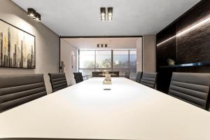 una sala de conferencias con una gran mesa blanca y sillas en Alta Garden Housi João Pessoa by Carpediem, en João Pessoa