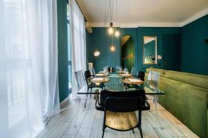 una sala da pranzo con pareti verdi e tavolo e sedie di ApartmentsArena - Corte delle Arti a Verona Altre 53 foto