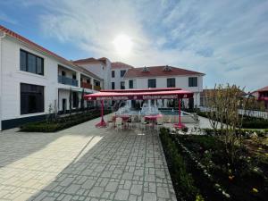 une terrasse avec des tables et des chaises devant un bâtiment dans l'établissement Magnolia Family Boutique and Spa, à İvanovka