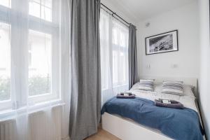 a bedroom with a bed and a large window at Monciak Comfort - Kamienica in Sopot