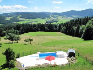 a large green field with a swimming pool in the middle at Holiday Home Marianne by Interhome in Baierweg