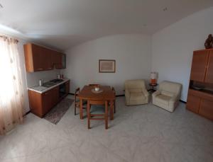 a living room with a table and a kitchen at Oikia Lodges in Grammichele