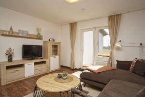 a living room with a couch and a tv and a table at Westphal`s Ferienwohnung in Groß Zicker