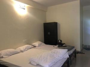 two twin beds in a room with a black cabinet at LAKE VIEW Chikkamagaluru in Chikmagalūr