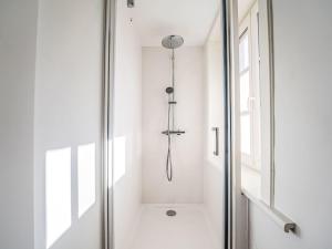 una doccia in un bagno bianco con porta in vetro di Apartment Malecot I by Interhome a Blankenberge