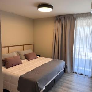 ein Schlafzimmer mit einem Bett und einem großen Fenster in der Unterkunft Faz Flat in Cordoba + 68 Fotos