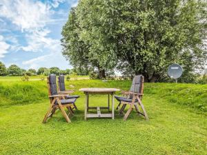 two chairs and a table in the grass at Holiday Home Kleine Reetdachkate by Interhome in Simonsberg