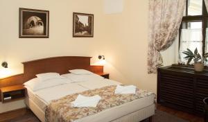 A bed or beds in a room at Hotel Klastrom